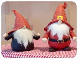Two red-hatted gnome figurines