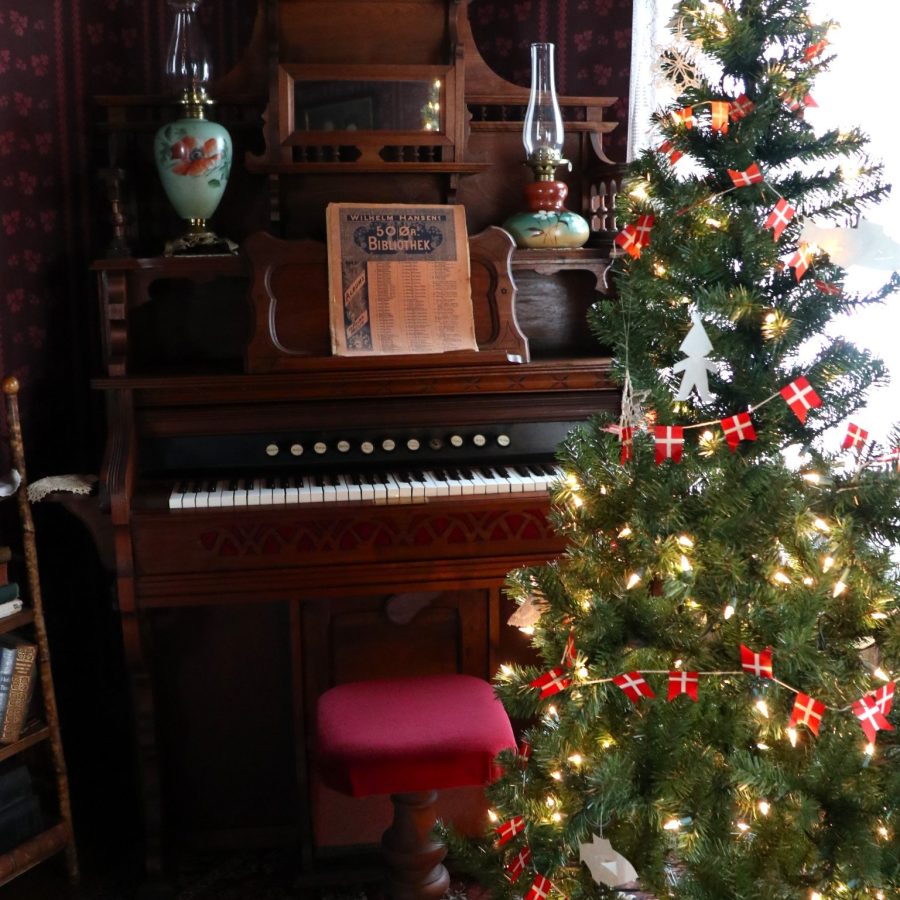 Holiday decorations and seasonal gathering scene inside a historic room.